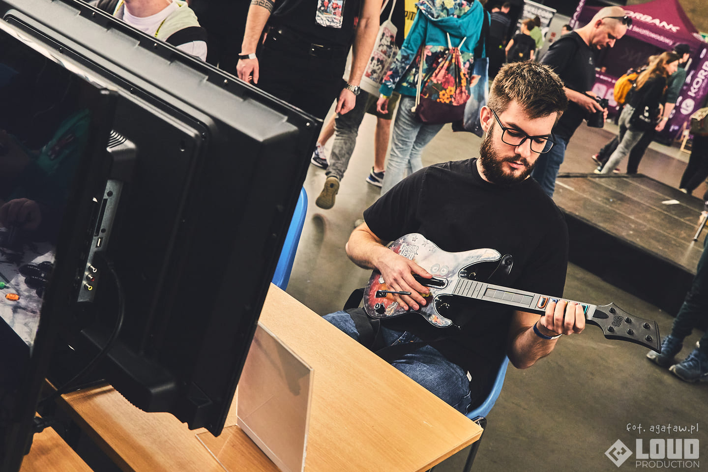 Uczestnicy grający w Guitar Hero podczas wydarzenia